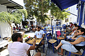 Menschen sitzen vor einem Restaurant, Pirgos, Insel Tinos, Kykladen, Griechenland, Europa