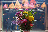 Bunte Blumen und Menschen in einem Tempel in Wanchai, Hongkong, China, Asien