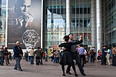 Menschen tanzen unter den Arkaden eines Gebäudes, Nanjing Road, Shanghai, China, Asien