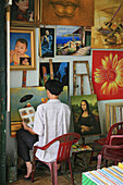 Man and reproductions of famous paintings in a shop, Saigon, Ho Chi Minh City, Vietnam, Asia
