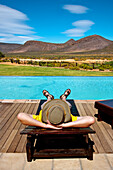 Man relaxing by the pool, Aquila Lodge, Cape Town, Western Cape, South Africa, Africa