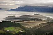 Fog over Goierri valley with Txindoki mountain of the Aralar mountain range in background. Guipuzcoa,  Basque Country,  Spain