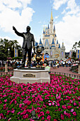 Statue of Walt Disney and Mickey Mouse in front of Cinderella Castle at Magic Kingdom Theme Park Orlando Florida Central