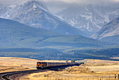 Freight train on the Montana plains near the Rocky Mountain Front Ranges of Glacier National Park USA