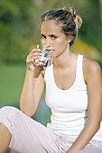 Young blonde woman drinking water