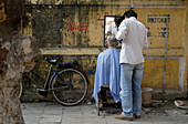 Street barber in the old town of Hanoi.
