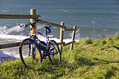 Mountain bicycle on a fence near the sea Langre beach,  Cantabria,  Spain,  Europe