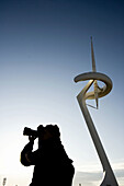 Hombre fotografiando en torre de telecomunicaciones telefónica de Montjuic,  Barcelona