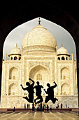 Tourist teens jumping in front of the Taj Mahal Agra,  India