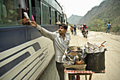 A man selling Chaat to bus riders Nepal