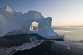 Blick auf Eisberg mit Loch vom Ilulissat Kangerlua Isfjord in der Abenddämmerung, Diskobucht, Kitaa, Grönland