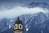 Church steeple with the Karwendel mountain range in the background, Church of St. Peter and Paul, Mittenwald, Karwendel Mountains, Bavaria, Germany