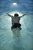 Swimmer swimming under water in an indoor swimming pool, Sport