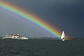 Sailing boat and ferry with rainbow, Lake Chiemsee, Bavaria, Germany