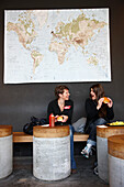 Two young women eating hamburgers in restaurant Burgers, Rocksresort, Laax, Canton of Grisons, Switzerland