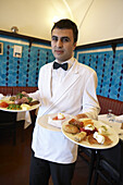 Waiter carrying two plates of food, Restaurant Pandeli, Istanbul, Turkey