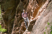 Hiker on sandstone rock, Wasigenstein, Alsace, France