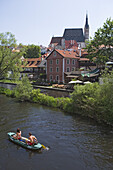 Canoeing on the Vltava river with the old town and the church of St. Veit in the back, Cesky Krumlov, South Bohemian Region, Czech Republic