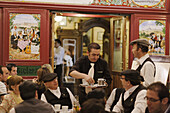 Waiter serving coffee in a pavement cafe, Fiestas de San Isidro Labrador, Madrid, Spain