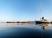 Sailboat on lake Chiemsee, Fraueninsel in background, Chiemgau, Bavaria, Germany