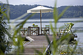 Outdoor furniture on jetty, Lake Simssee, Bavaria, Germany