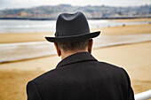 Senior man with hat at San Lorenzo beach, Gijon, Asturias, Spain