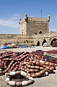 Stadtmauer und Fischernetze im Hafen von Essaouira, Marokko