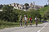 Radfahrergruppe vor der Kulisse von Urbino, Marken, Italien, Europa