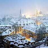 prague - winter view of mala strana rooftops covered with snow