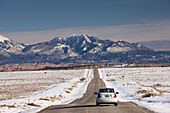 Park road and the La Sal Mountains in winter, Dead Horse Point State Park, Moab, Utah, USA