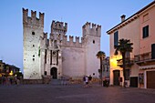 Italy, Lombardy, Lake District, Lake Garda, Sirmione, Castello Scaligero, b 1250, from Piazza Castello, dusk