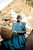 Old man of the Dogon people with basket, La Falaise de Bandiagara, Mali, Africa