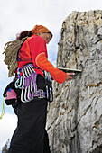 Woman with climbing gear and climbing rope reading a guidebook, Massa, Tuscany, Italy