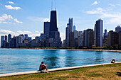 Young man sitting on the lake shore, North Lake Shore, Chicago, Illinois, USA