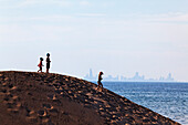 Kids standing on a sand dune in Indiana Dunes National Lakeshore park, silhouette of Downtown Chicago in the background, Indiana, USA