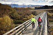 Cyclists crossing bridge, Otago Rail Trail, Otago, New Zealand