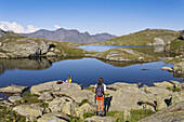 Two female hikers resting near lakes Flueeseen at Stallerberg, Juf, Canton of Grisons, Switzerland