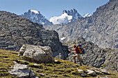 Hiker ascenting to Bocca di Montandayne, Piccolo Paradiso and Gran Paradiso in background, Gran Paradiso National Park, Aosta Valley, Italy