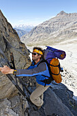 Mann auf einer Leiter zur Passage du Grand Neyron, Nationalpark Gran Paradiso, Aostatal, Italien