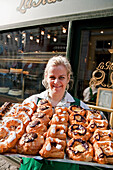 Shop assistant mit danish pastries in front of La Glace bakery shop, famous old bakery, Copenhagen, Denmark
