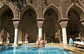 Young woman in the swimming pool at Riad La Sultana, Luxury Hotel, Marrakech, Morocco, Africa