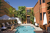 Woman sitting next to the swimming pool, Spa Riad Mehdi, Marrakech, Morocco, Africa