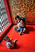 Man with children inside Wat Mongkol Bobit temple, old kingdomtown Ayutthaya, Thailand, Asia