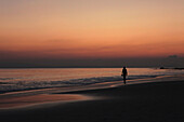 Eine Person am Radha Nagar Beach bei Sonnenuntergang, Strand 7, Havelock Island, Andamanen, Indien