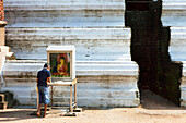 Sinhalese boy praying in front of a Buddha statue in the Mirisawetiya Dagoba, Sacred City, Anuradhapura, Sri Lanka, Asia