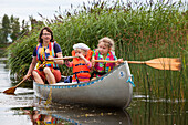 Eine Frau und zwei Mädchen, Kinder in einem Kanu auf der Insel Norrbyskär, Västerbotten, Schweden, Europa