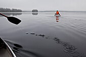 Zwei Männer in Kanus auf dem See von Trehörningsjö, Västernorrland, Schweden, Europa