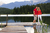 Young couple on jetty, lake Lautersee, Mittenwald, Werdenfelser Land, Upper Bavaria, Germany