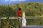 Young couple on jetty, lake Lautersee, Mittenwald, Werdenfelser Land, Upper Bavaria, Germany