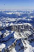 Heißluftballon fliegt hoch über der Südwand der Marmolada im Winter, Dolomiten und Tauern im Hintergrund, Luftaufnahme, Dolomiten, Venetien, Italien, Europa